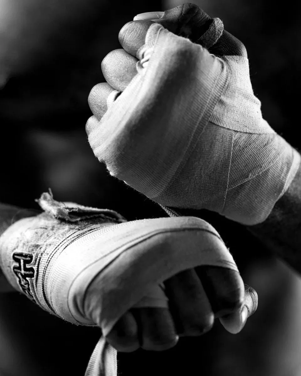 Manos de un luchador vendándose antes de entrenar, en blanco y negro